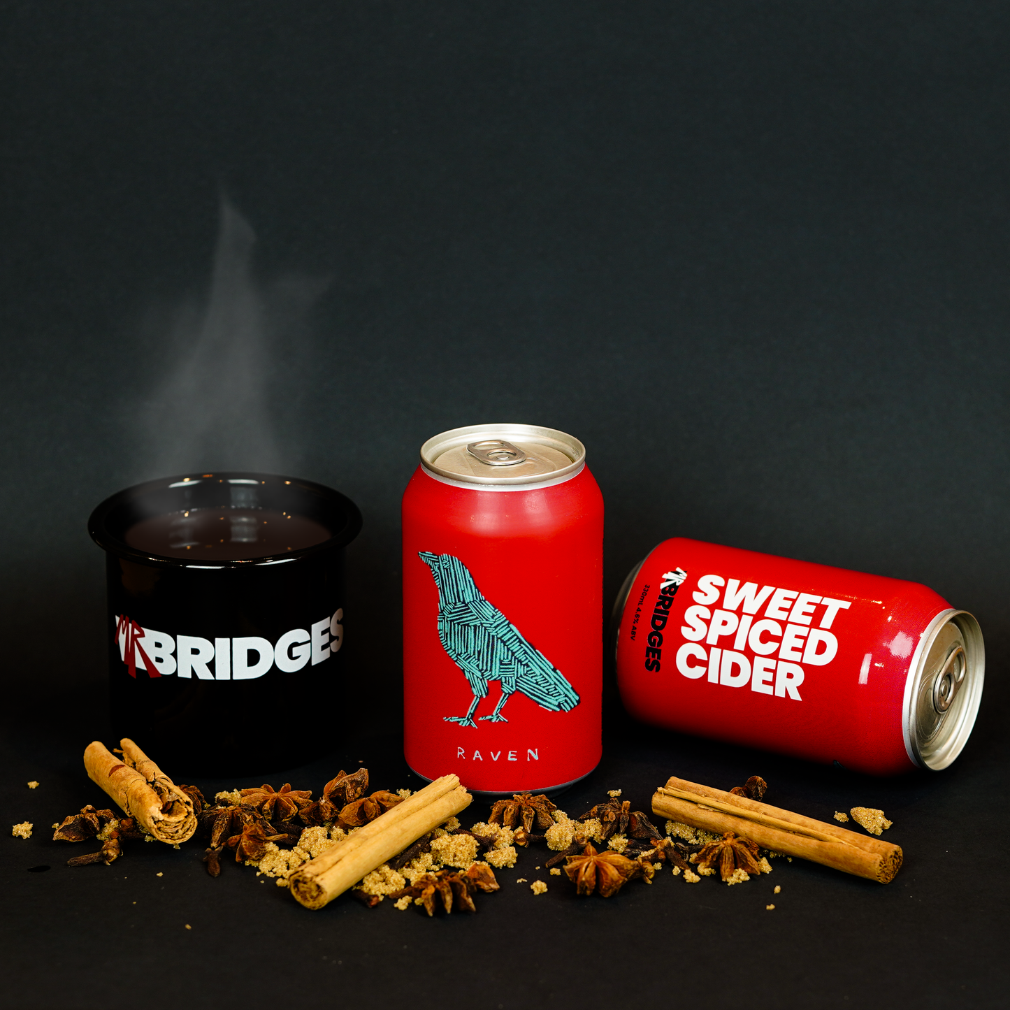 Mr Bridges red Sweet Spiced Cider cans with branded enamel mug and decorative spices.