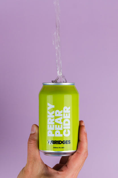 Green can of Perky Pear Cider by Mr Bridges being tipped from can to show clarity of product.